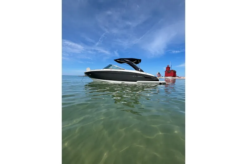 Slide: The Image of 2017 Regal 2800 Bowrider boat on calm water near a red lighthouse under blue sky. - 4