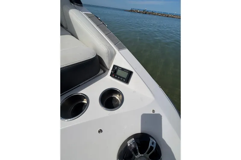 Slide: The Image of 2017 Regal 2800 Bowrider interior with cup holders and control panel by the water. - 23