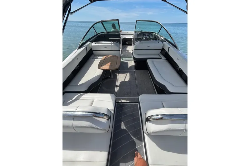 Slide: The Image of 2017 Regal 2800 Bowrider boat interior with spacious seating and wooden table on calm water. - 10