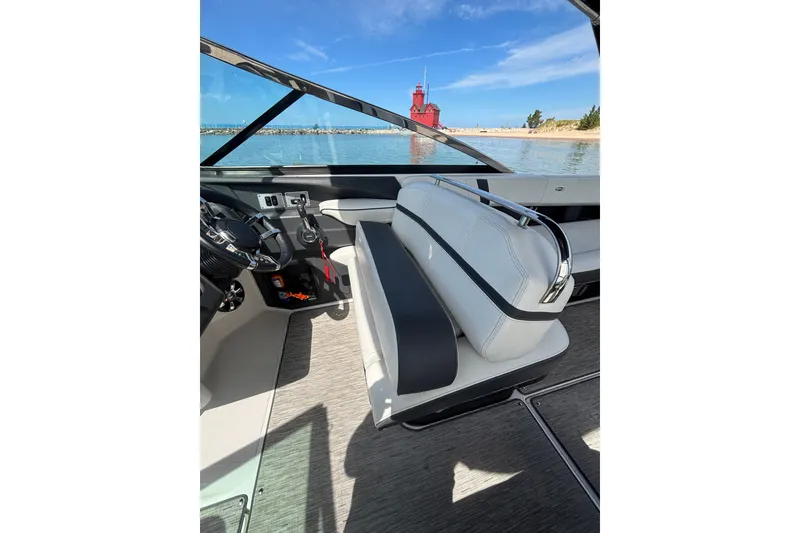 Slide: The Image of 2017 Regal 2800 Bowrider interior with steering wheel, white seating, and scenic water view. - 16