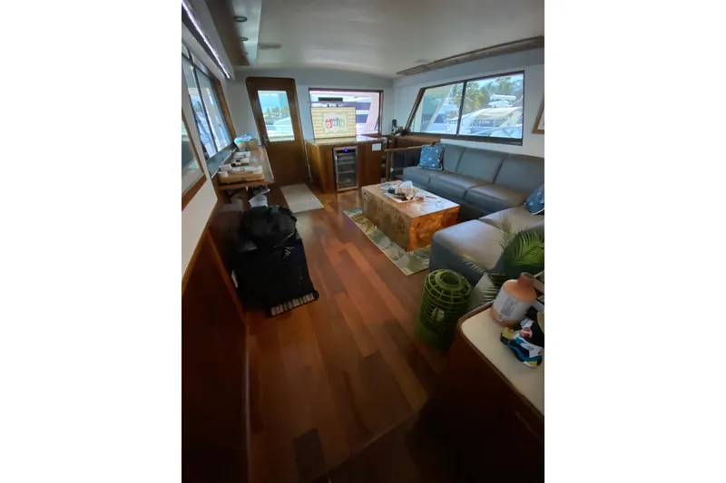 Slide: The Image of Interior of 1990 Hatteras 67 Cockpit Motor Yacht with elegant wood flooring and modern furnishings. - 30