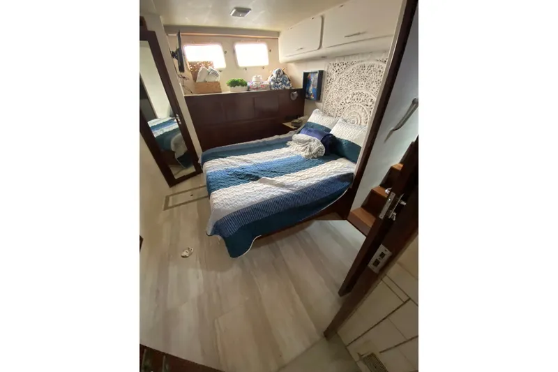 Slide: The Image of Cozy bedroom in 1990 Hatteras 67 Cockpit Motor Yacht with blue-striped bedding. - 25