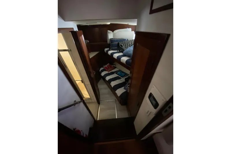 Slide: The Image of Innenraum einer Hatteras 67 Cockpit Motor Yacht von 1990 mit Etagenbetten und Holzwänden. - 28
