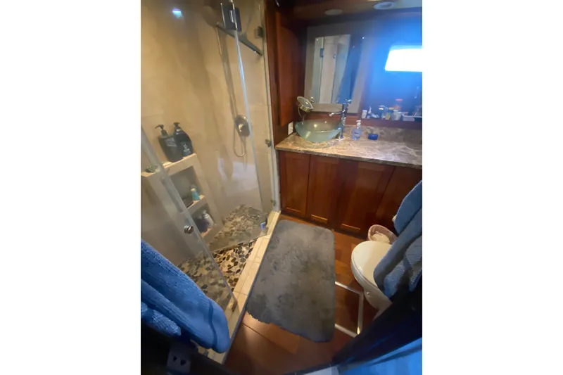 Slide: The Image of Luxurious bathroom in 1990 Hatteras 67 Cockpit Motor Yacht with glass shower and elegant vanity. - 8