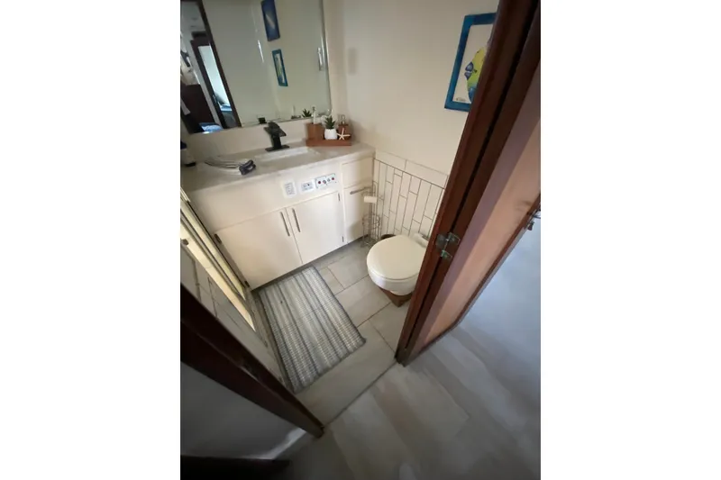 Slide: The Image of Bathroom interior of 1990 Hatteras 67 Cockpit Motor Yacht, featuring sink and toilet. - 24
