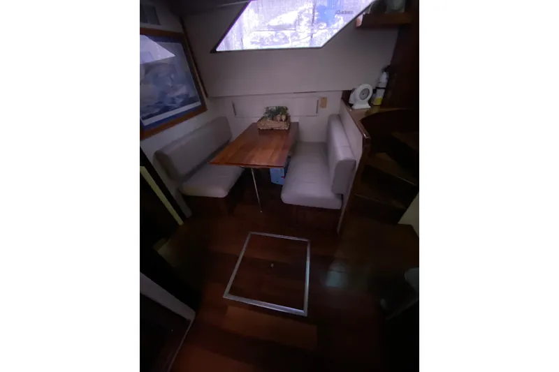 Slide: The Image of Interior of 1990 Hatteras 67 Cockpit Motor Yacht with dining area and wooden flooring. - 31