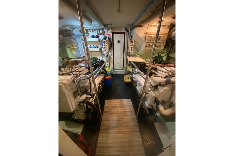 Slide: The Image of Engine room of 1990 Hatteras 67 Cockpit Motor Yacht, showcasing machinery and equipment. - 13