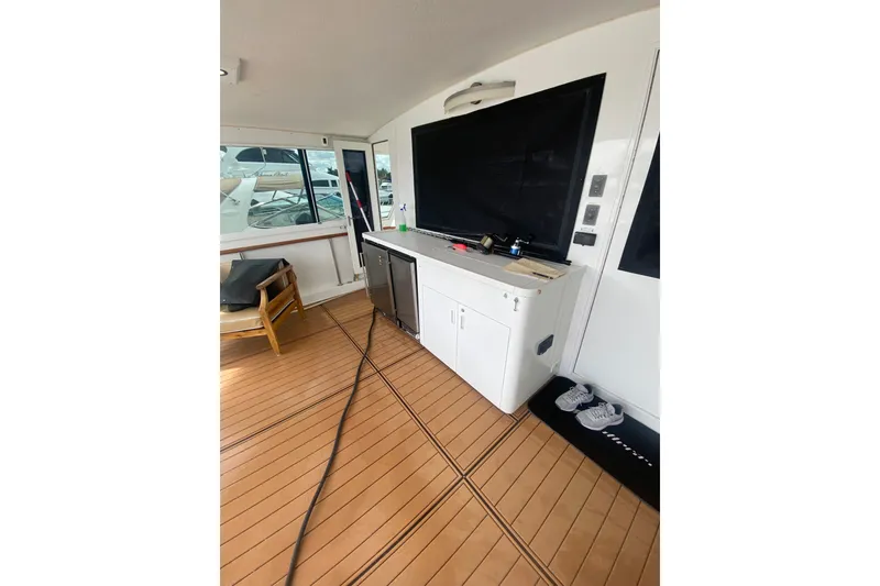 Slide: The Image of 1990 Hatteras 67 Cockpit Motor Yacht interior with wooden flooring and white cabinetry. - 4