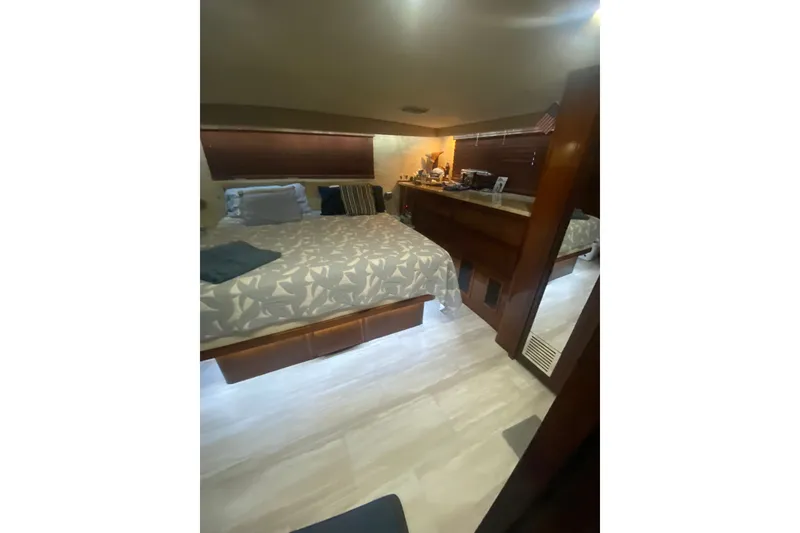 Slide: The Image of Cozy bedroom interior of 1990 Hatteras 67 Cockpit Motor Yacht with wooden accents. - 9