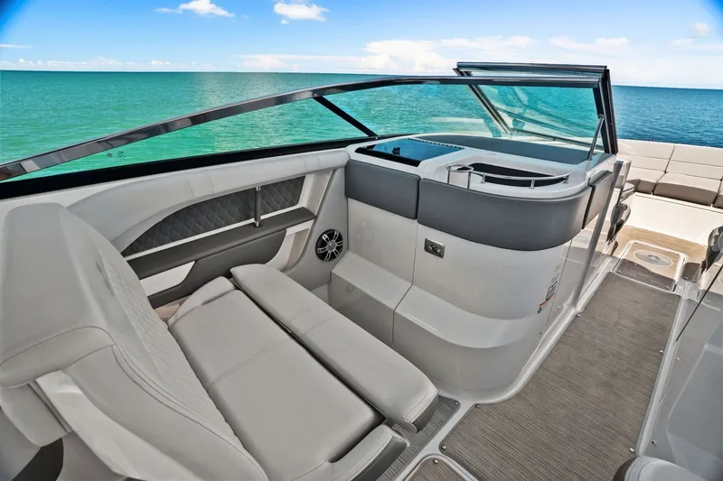 Slide: The Image of The image shows the cockpit of a 2023 Sea Ray SLX 310 Outboard with luxurious seating and a clear view of the sea. - 31