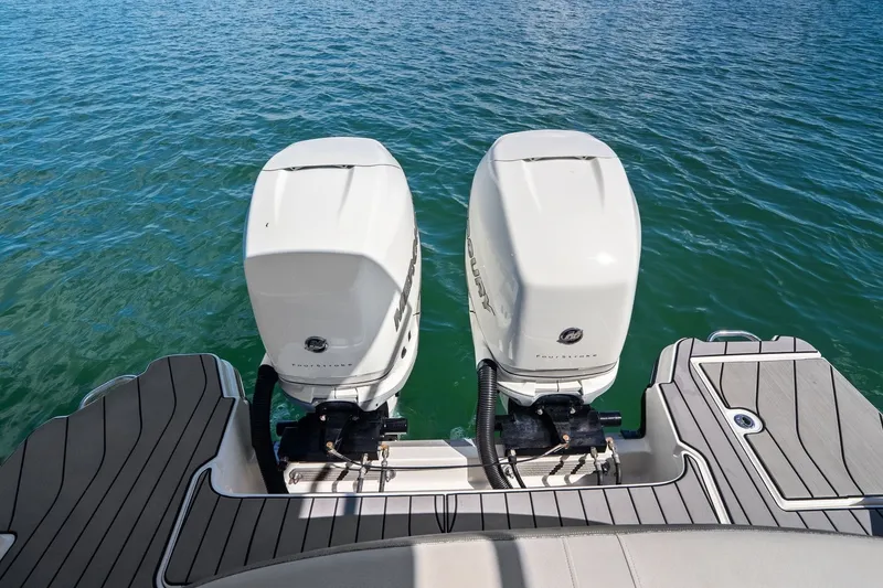Slide: The Image of Two outboard engines on a boat, floating on calm water. - 47