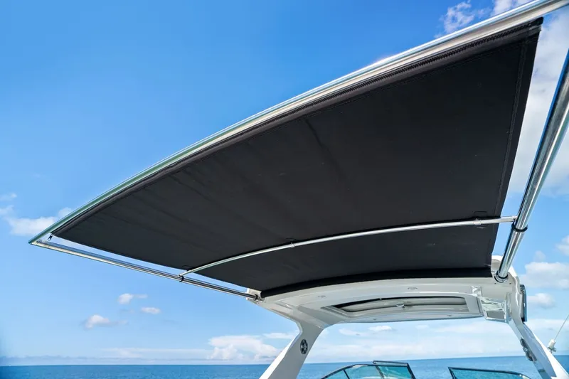 Slide: The Image of The image shows the sunshade of a Sea Ray SLX 310 Outboard boat under a clear blue sky. - 43
