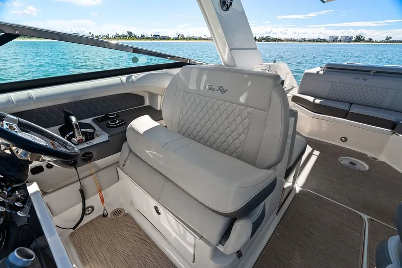 Slide: The Image of The image shows the cockpit of a 2023 Sea Ray SLX 310 Outboard boat with gray upholstery. - 25