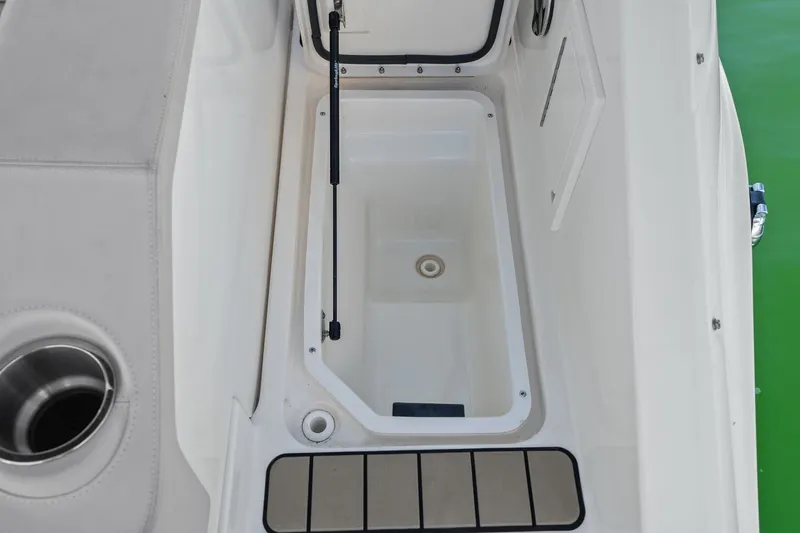 Slide: The Image of An open storage compartment on a Sea Ray SLX 310 Outboard boat, surrounded by white surfaces. - 44