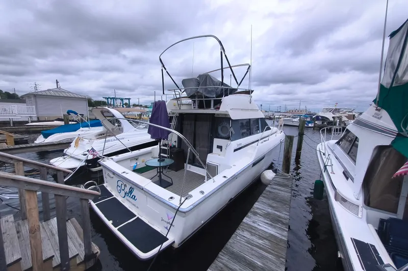 The Image of 1991 Silverton 37 Convertible yacht docked at marina under cloudy skies. - 1