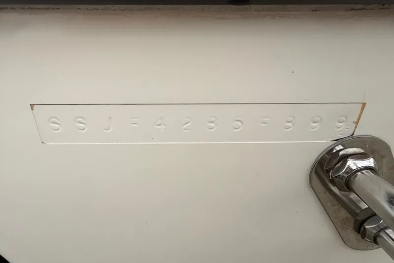 Slide: The Image of Hull identification number on 1999 Pursuit 2460 Denali boat, embossed on white surface. - 9
