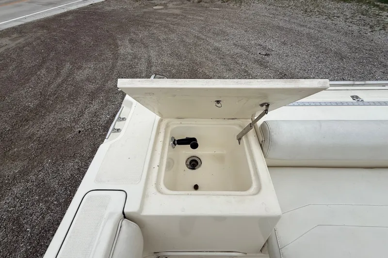 Slide: The Image of Open storage compartment on 1999 Pursuit 2460 Denali boat, showing interior details. - 22