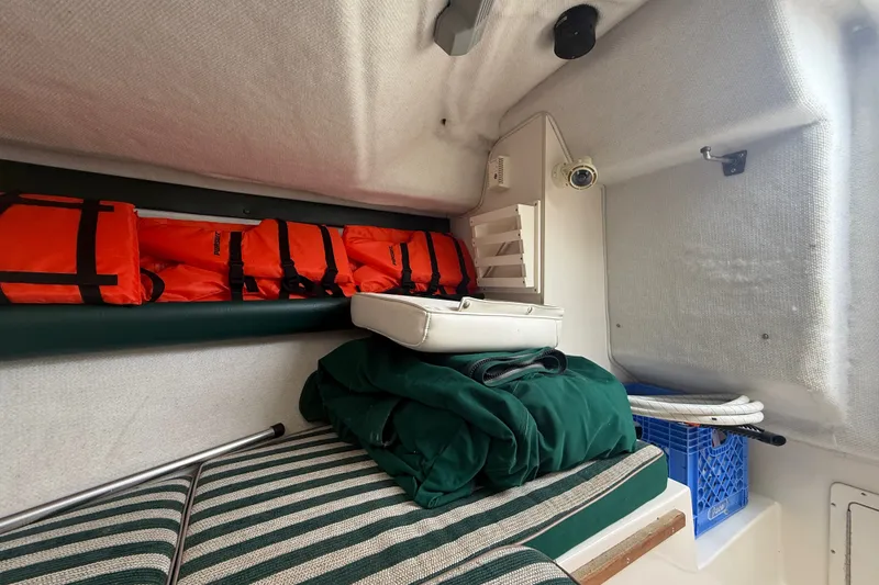 Slide: The Image of Interior of 1999 Pursuit 2460 Denali boat with life jackets and storage. - 28