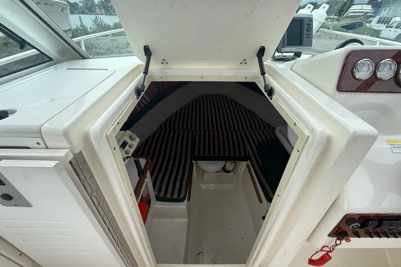 Slide: The Image of 1999 Pursuit 2460 Denali cabin interior with striped upholstery and control panel. - 23