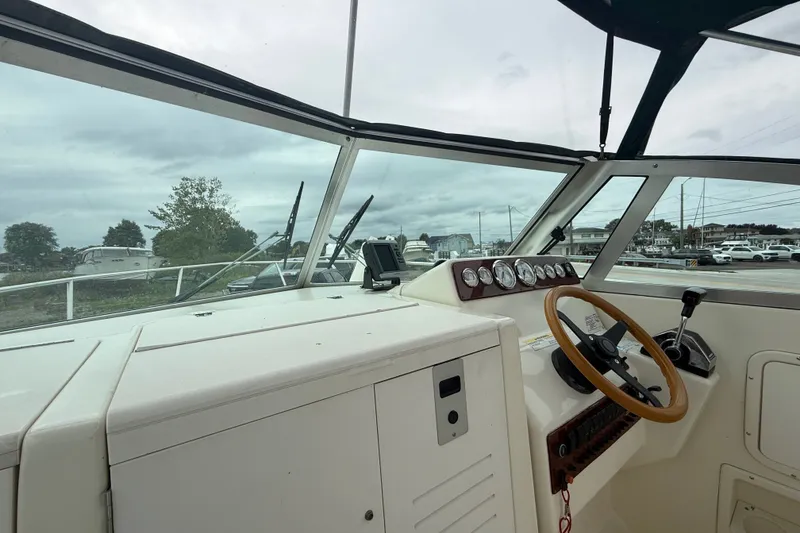 Slide: The Image of Interior view of 1999 Pursuit 2460 Denali boat cockpit with steering wheel and gauges. - 10