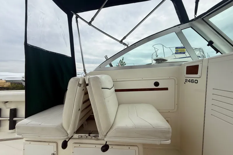 Slide: The Image of 1999 Pursuit 2460 Denali boat interior with white seating and canopy. - 16