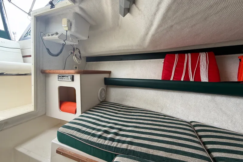 Slide: The Image of Interior cabin of a 1999 Pursuit 2460 Denali boat with striped cushions and safety equipment. - 27