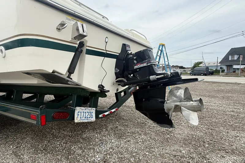 Slide: The Image of 1999 Pursuit 2460 Denali boat on trailer, featuring MerCruiser engine and propeller. - 7