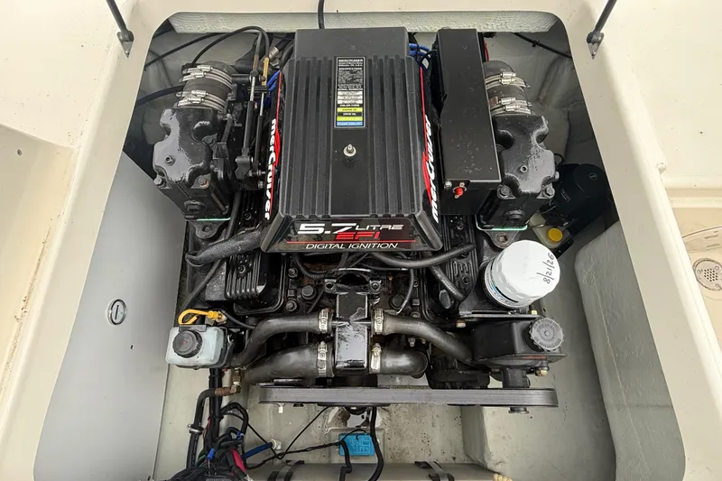 Slide: The Image of Engine compartment of a 1999 Pursuit 2460 Denali boat, featuring a 5.7L MerCruiser engine. - 33