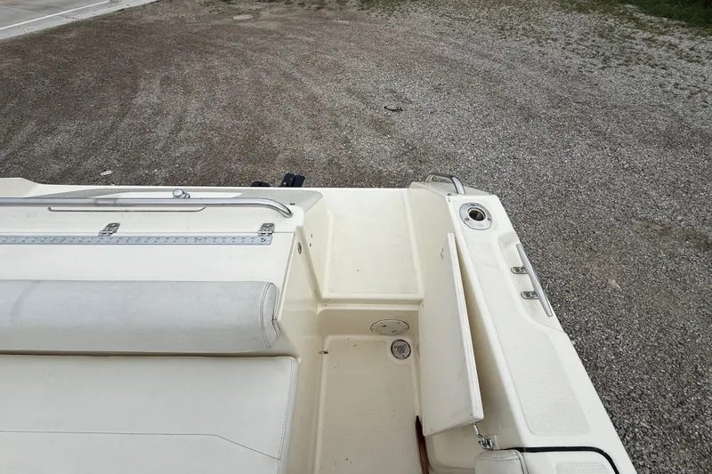 Slide: The Image of 1999 Pursuit 2460 Denali boat interior with seating and storage compartments. - 21