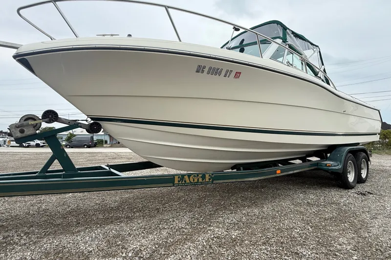Slide: The Image of 1999 Pursuit 2460 Denali boat on trailer, displayed outdoors, side view. - 5