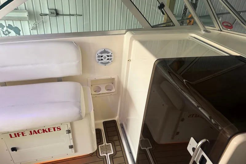 Slide: The Image of Interior of a 2000 Pursuit 3000 Express boat with seating and life jacket storage. - 12