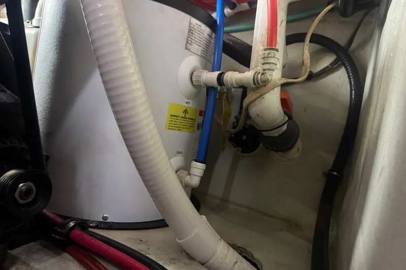 Slide: The Image of Engine compartment of a 2000 Pursuit 3000 Express boat, showing hoses and connections. - 27