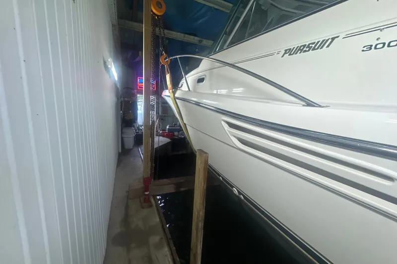 Slide: The Image of 2000 Pursuit 3000 Express boat docked in a covered marina. - 3