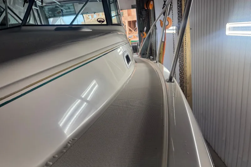 Slide: The Image of 2000 Pursuit 3000 Express boat in storage, showcasing sleek design and railing details. - 5
