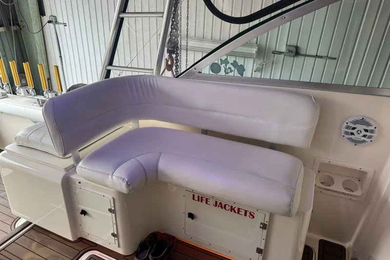 Slide: The Image of Interior of 2000 Pursuit 3000 Express boat with white seating and life jacket storage. - 11