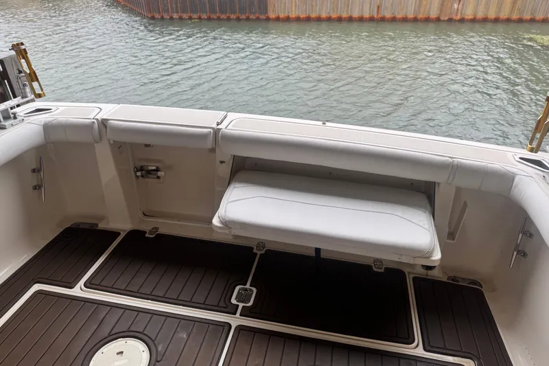 Slide: The Image of 2000 Pursuit 3000 Express boat interior with cushioned seating and wooden flooring. - 16