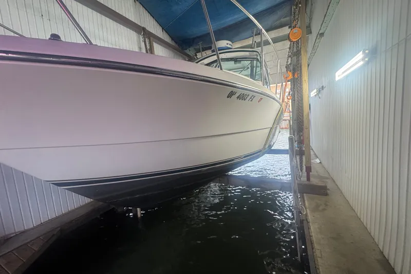 Slide: The Image of 2000 Pursuit 3000 Express boat docked in a covered marina. - 2