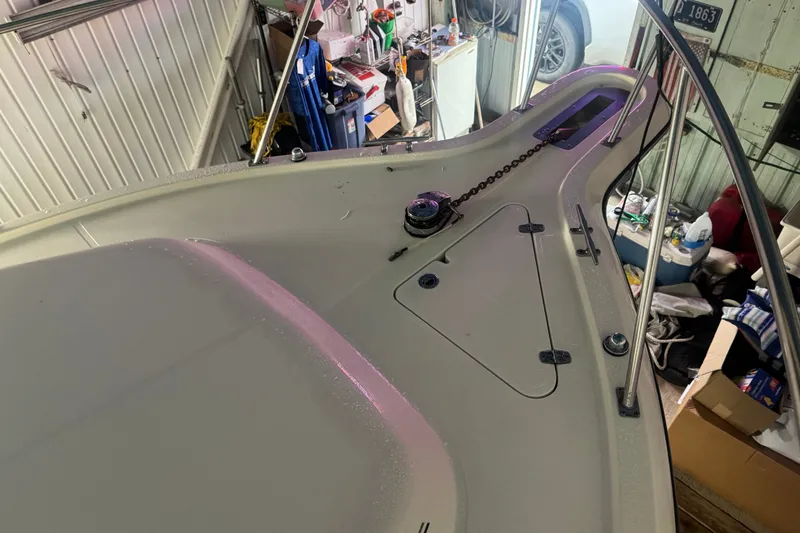Slide: The Image of 2000 Pursuit 3000 Express boat deck in a garage with visible anchor chain. - 6