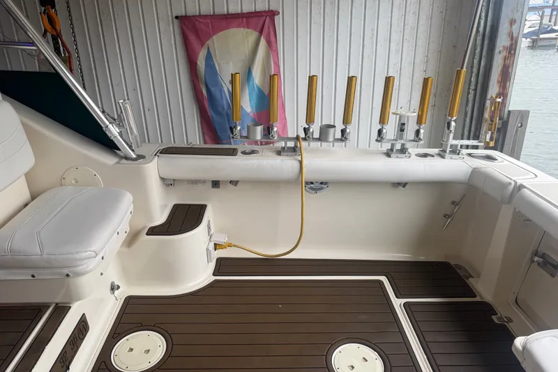 Slide: The Image of 2000 Pursuit 3000 Express boat interior with fishing rod holders and seating. - 17