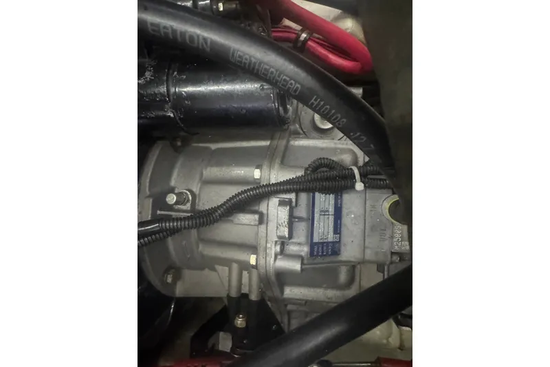 Slide: The Image of Engine compartment of a 2000 Pursuit 3000 Express boat, featuring hoses and wiring. - 29
