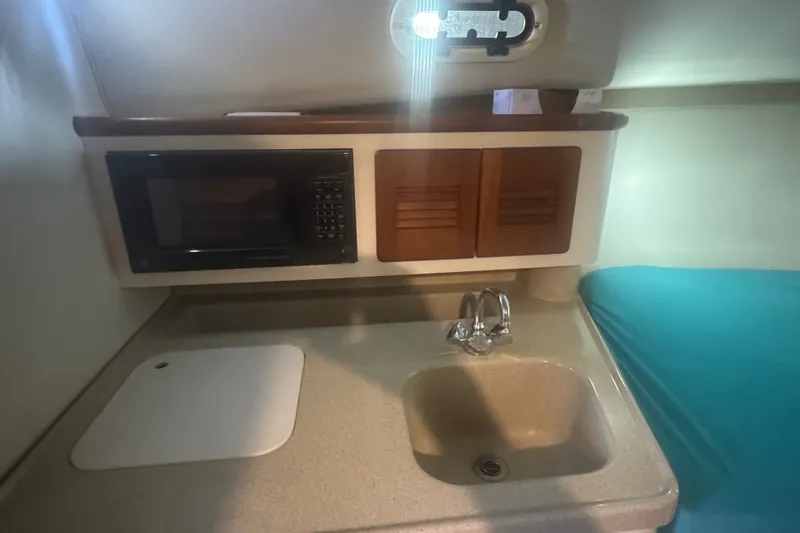 Slide: The Image of Compact kitchen area in a 2000 Pursuit 3000 Express boat with sink and microwave. - 20