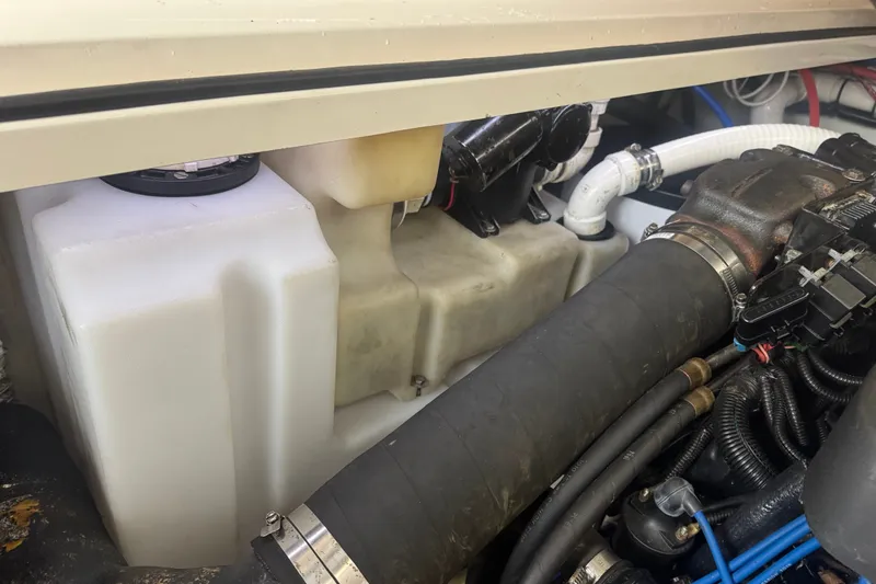 Slide: The Image of Engine compartment of a 2000 Pursuit 3000 Express boat, showing hoses and components. - 28