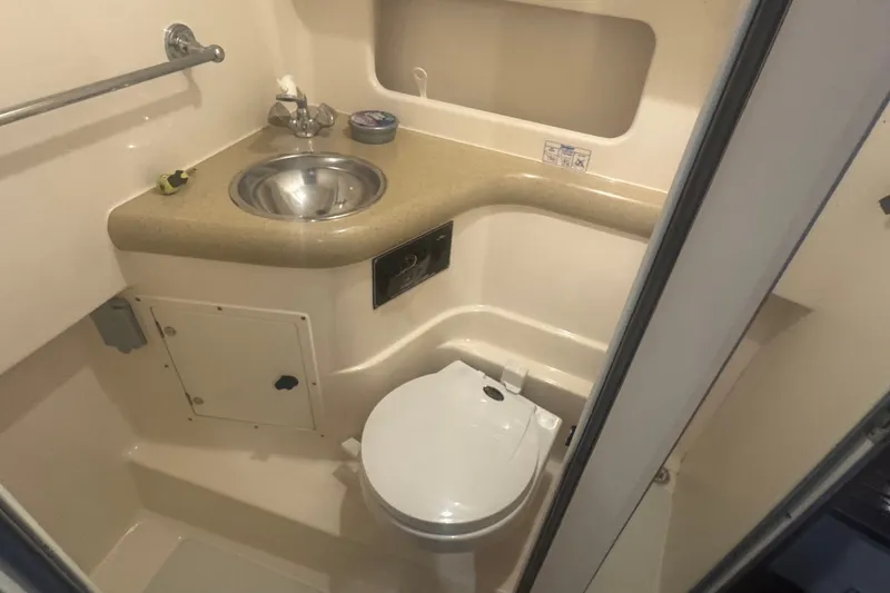 Slide: The Image of Compact bathroom in 2000 Pursuit 3000 Express boat with sink and toilet. - 21