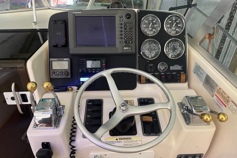 Slide: The Image of Control panel of a 2000 Pursuit 3000 Express boat with steering wheel and gauges. - 9