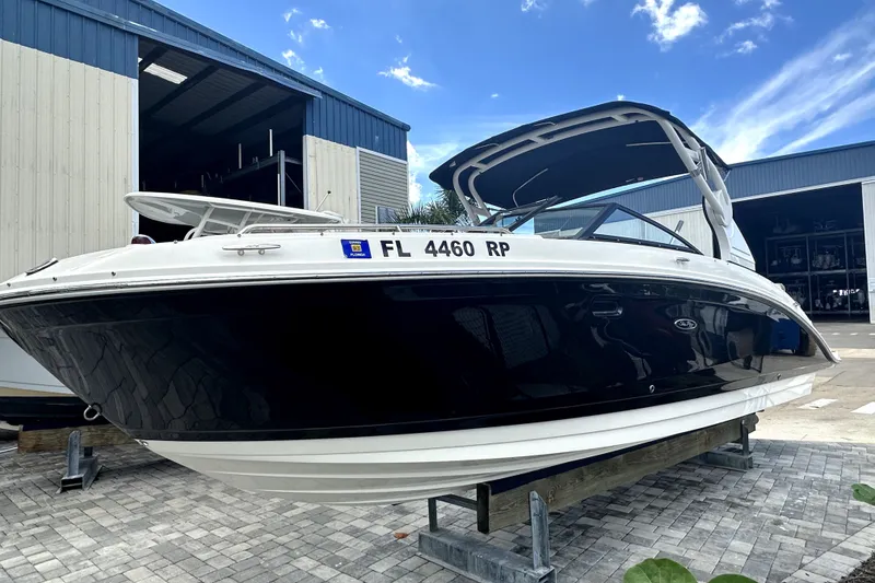 Slide: The Image of 2018 Sea Ray SDX 270 Outboard boat on display, docked near a storage facility. - 1