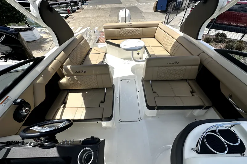 Slide: The Image of 2018 Sea Ray SDX 270 Outboard boat interior with beige seating and steering wheel. - 9