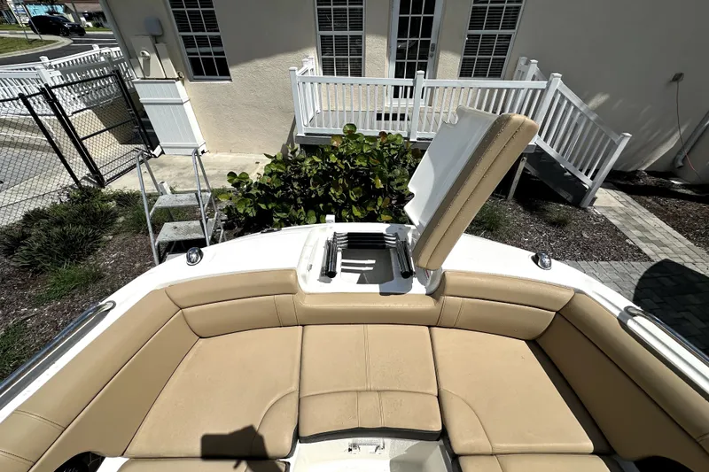 Slide: The Image of 2018 Sea Ray SDX 270 Outboard boat with open storage compartment and beige seating. - 6