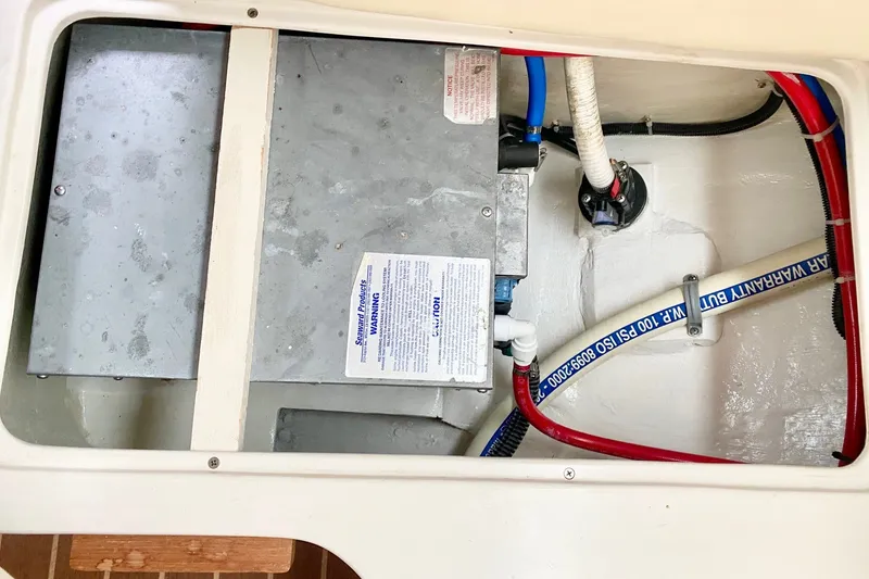 Slide: The Image of Catalina 309 (2007) boat interior showing plumbing and wiring components. - 36