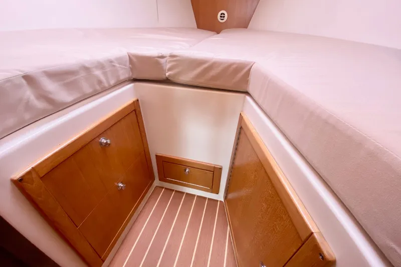Slide: The Image of Interior cabin of 2007 Catalina 309 sailboat with wooden cabinets and cushioned bed. - 22