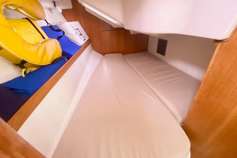 Slide: The Image of Cozy cabin interior of 2007 Catalina 309 sailboat with life jacket and storage. - 34